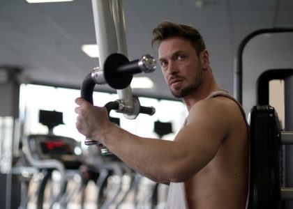 Focused man working out in a gym, showcasing biceps and determination.